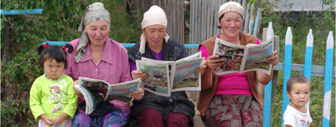Rural_women_near_Issykul_reading_AA_newspaper.jpg